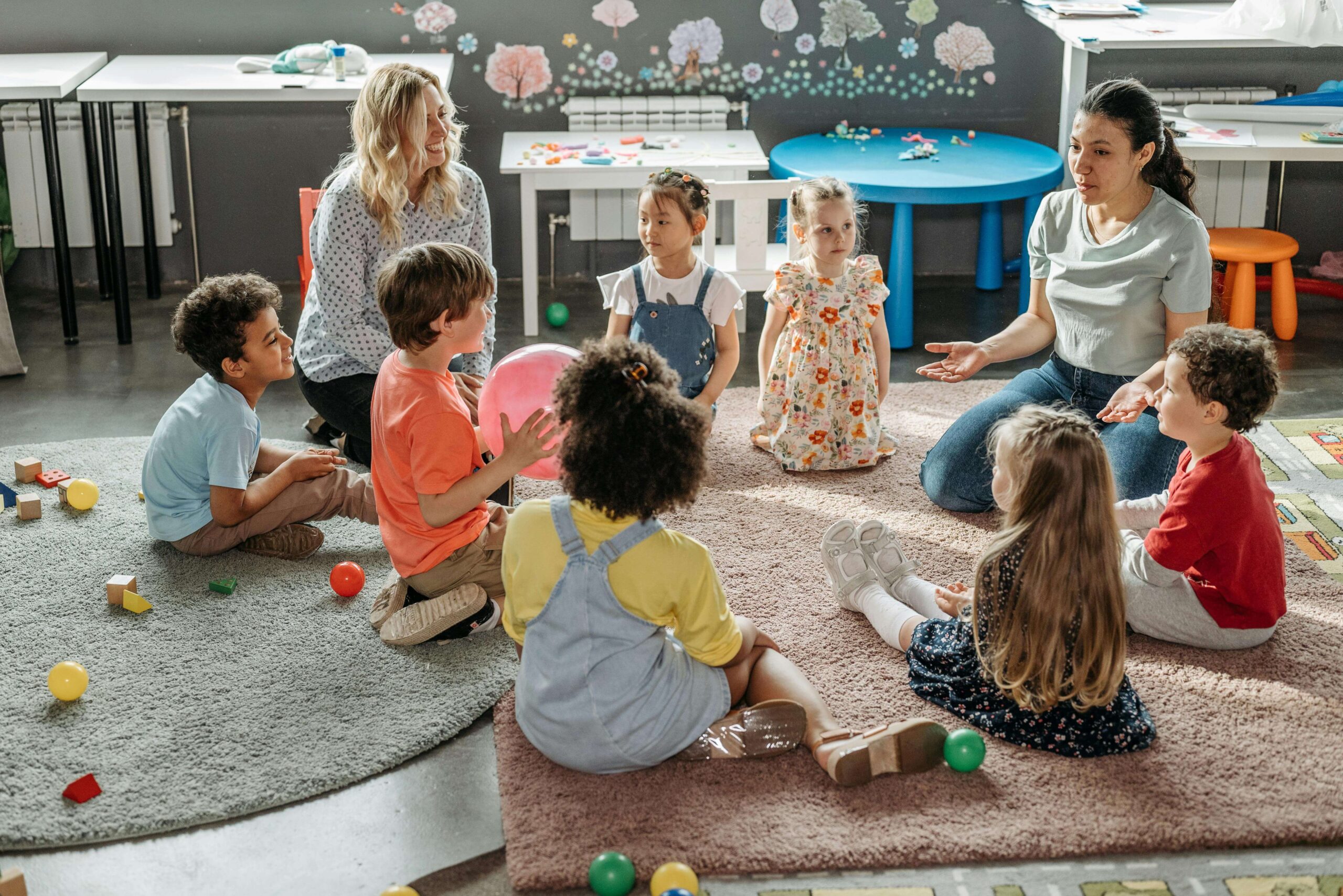 Bright, cheerful nursery classroom with children engaged in play.