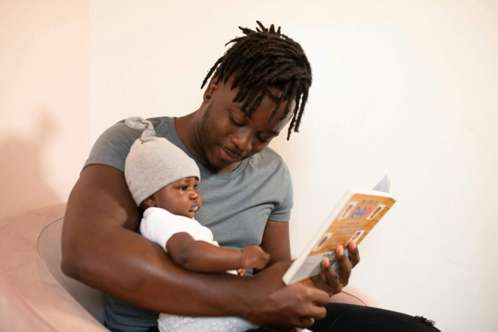 Parent reading a book with toddler at home.