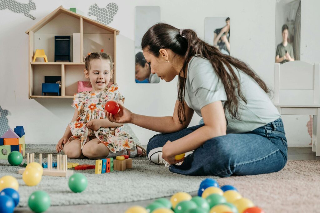 Child playing with teacher supporting.