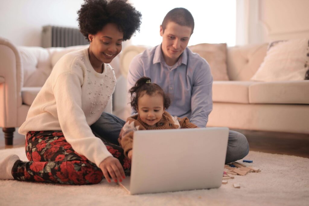 Parent comparing nursery options on laptop with notes.